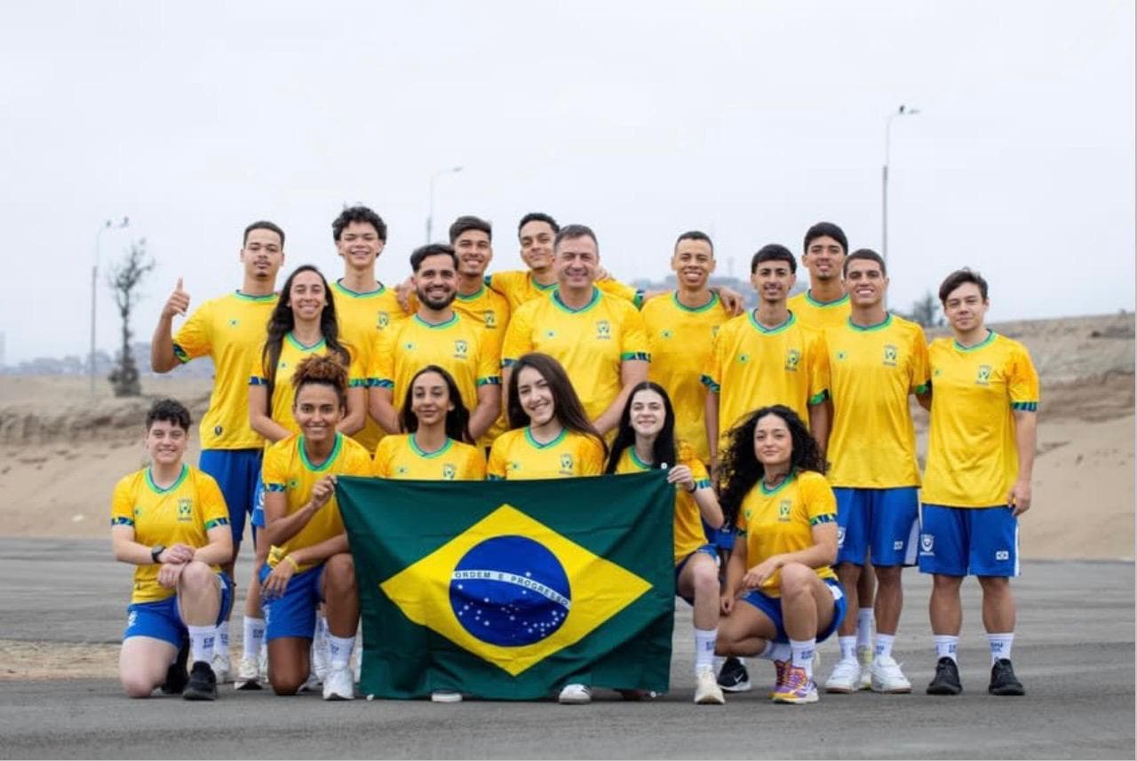 Delegação brasileira de taekwondo reunida com a bandeira do Brasil